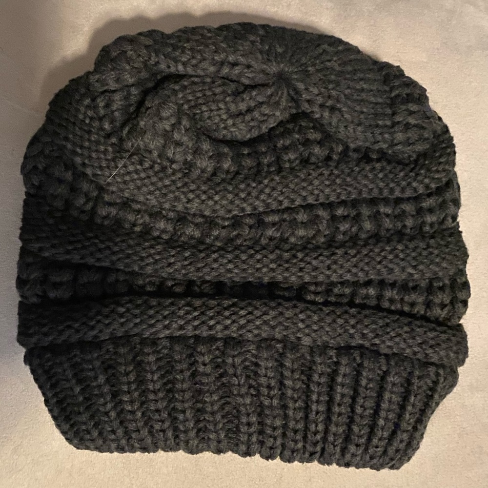 Dark grey knit beanie with criss cross opening on the back for ponytails.